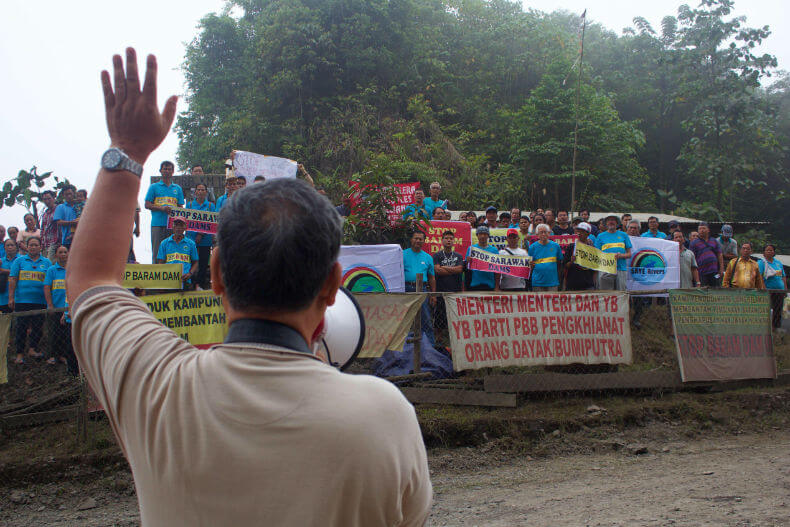 Peter Kallang, Chairman of SAVE Rivers, rallies the crowd at the blockade at Kilometer 15
