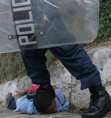 Peru police officer stepping on indigenous man
